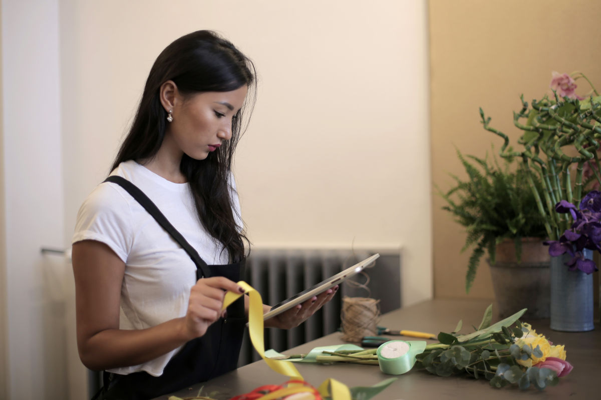 Ondernemer bekijkt in winkel rapporten en overzichten op iPad