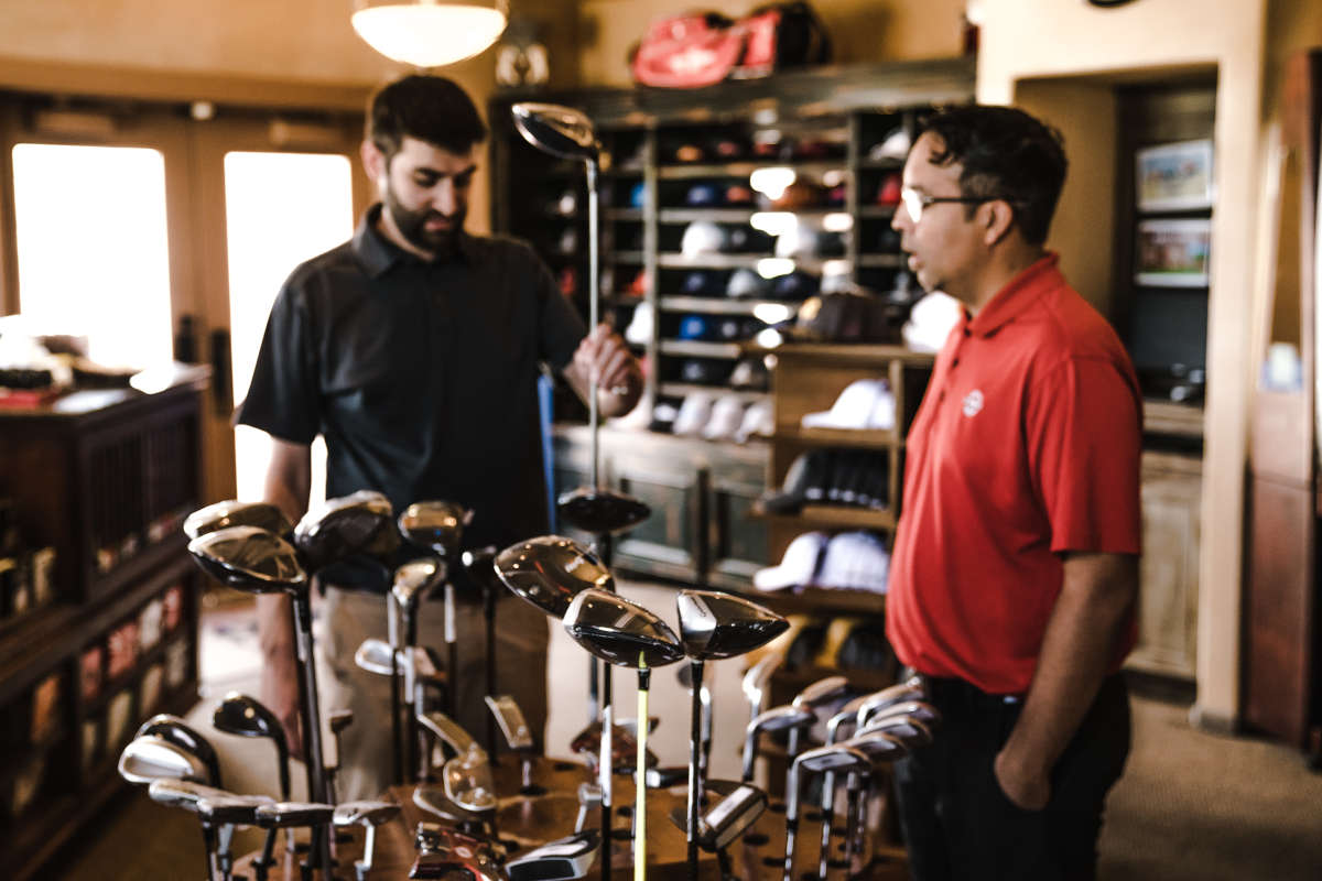 Medewerker en klant in sportwinkel voor golf