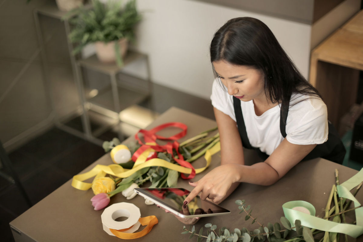 Medewerker in huis & tuinwinkel aan het werk met kassasysteem op tablet