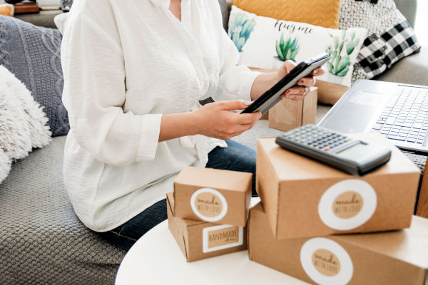 Verkopen via Zalando: Afbeelding toont persoon met tablet in handen, omringt door dozen, rekenmachine en laptop