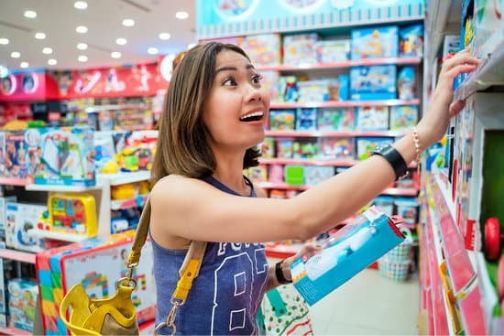 Vrouw kijkt naar producten in speelgoedwinkel